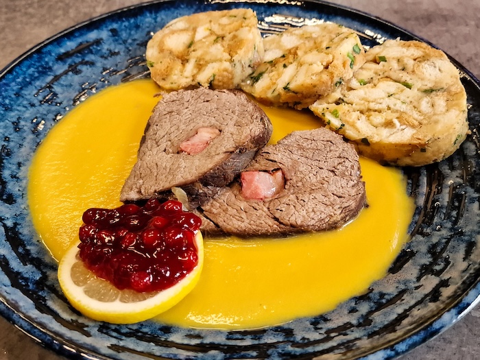 Svíčková na smetaně – Marinated beef sirloin in a creamy vegetable sauce, served with dumplings and cranberry sauce.